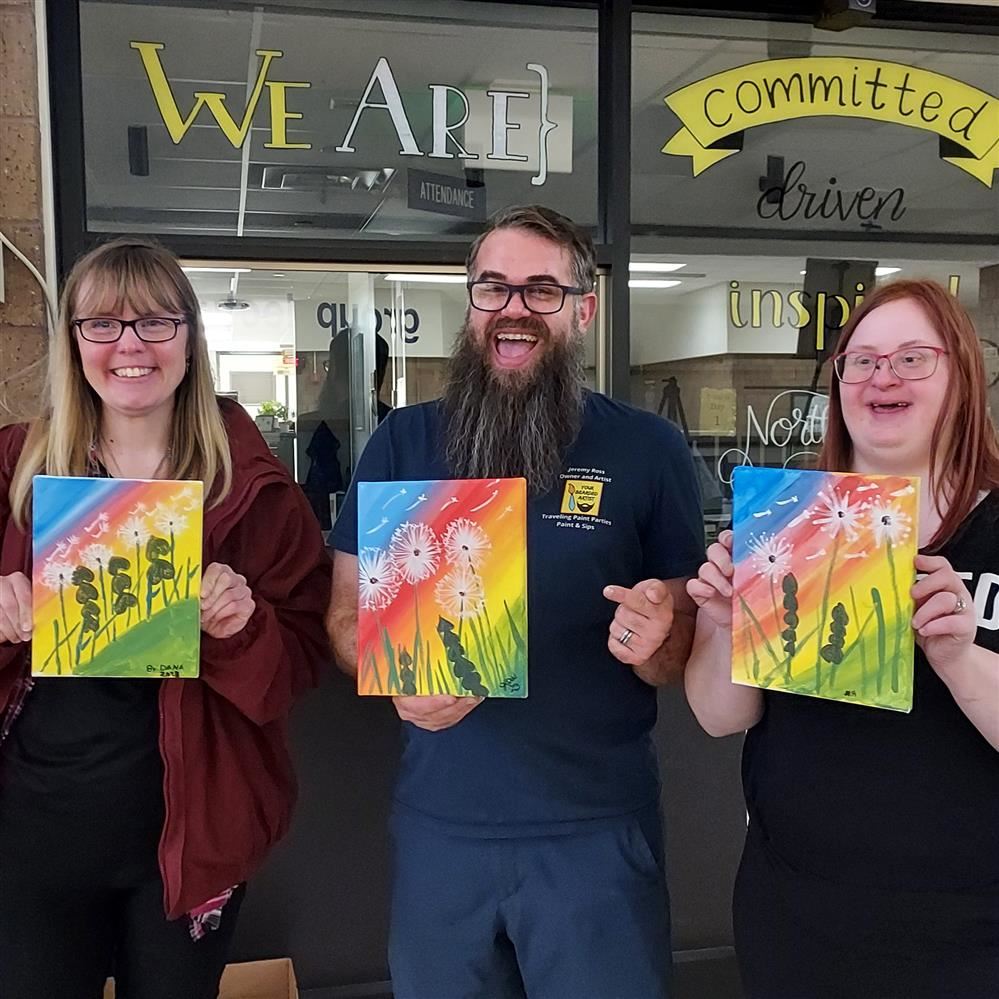  Three adults holding paintings
